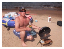 Captain John Wagner grilling the catch on the beach
